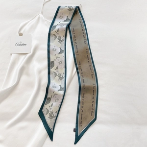 Schmaler Twilly-Schal mit Blumendruck auf weißem Satinkleid für elegantes Styling