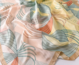 Detailed view of the soft satin texture and abstract leaf pattern on this silk-like scarf