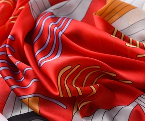 Macro shot of smooth red satin scarf fabric with orange and violet abstract wavy lines