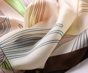 Close-up of elegant silk scarf showing soft fabric texture and abstract color block pattern