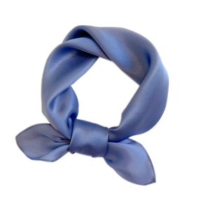 Elegant solid blue silk square scarf with a satin finish tied in a stylish knot