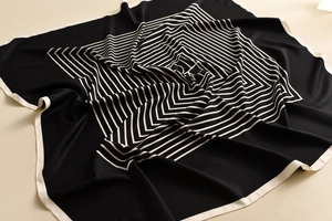 Detail of elegant black and white striped silk scarf with premium hemmed edges