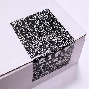 Detail of black and white graffiti stickers on a cardboard box with cartoon gift icons