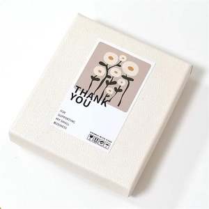 Close-up of white textured gift box with cactus floral Thank You label and safety icons