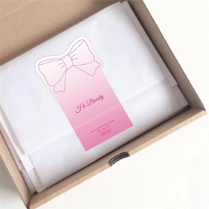 Pink bow packaging stickers with Hi Beauty text inside a gift box with tissue paper