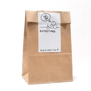 Brown kraft gift bag with a vertical white sticker featuring clean black line art
