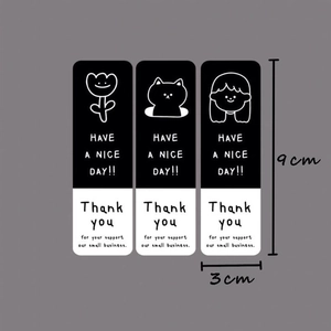 Detailed view of black and white rectangular 3x9cm stickers with cat and floral motifs