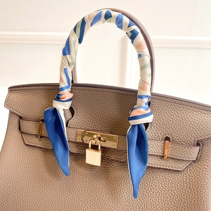 Braune Lederhandtasche mit geometrischem Seidenschal und goldenen Metallbeschlägen