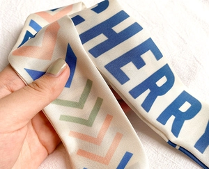 Detailansicht des Chevron-Musters und der hochwertigen Twill-Seidentextur des bedruckten Schals