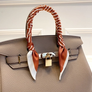 Sac à main en cuir gris foncé avec foulard en soie orange et fermoir doré élégant