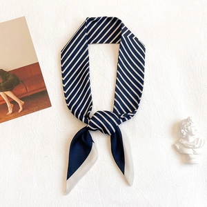 Foulard en soie rayé bleu marine et blanc avec finition satinée noué avec style