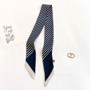 Détail d'un foulard en soie à rayures bleu marine et blanc avec des pointes effilées