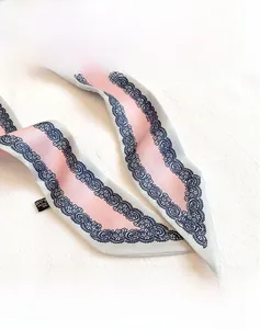 Dettaglio della cucitura interna e dell'etichetta 100% poliestere dello scialle di seta rosa