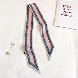 Dettaglio di foulard rosa con bordo in pizzo e spilla di perle elegante come accessorio