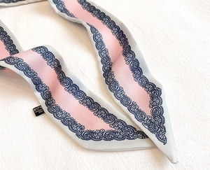 Dettaglio della sciarpa twilly blu-grigio con motivo paisley e pizzo delicato