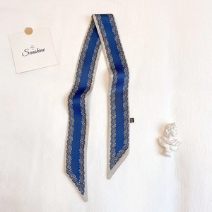 Dettaglio di sciarpa in seta Paisley blu scuro con motivi in pizzo su fondo bianco