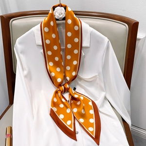 Orange polka dot skinny silk scarf styled on a white shirt collar for women