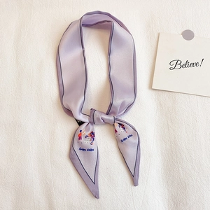 Détail d'un foulard en soie lilas avec illustration de Pâques et bordure noire