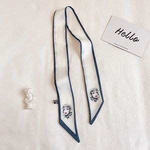 Détail d'un foulard étroit en soie avec portrait rétro et bordures bleu foncé