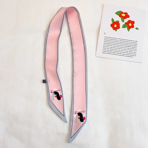 Détail d'une écharpe étroite rose avec portrait de femme et texte Love Yourself