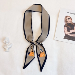 Détail d'un foulard en soie gris avec illustration féminine moderne et boucle métallique dorée