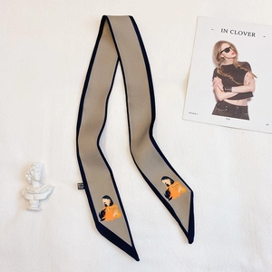 Détail d'un foulard Twilly en soie avec imprimé portrait et bordures bleu foncé