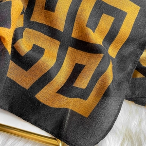 Macro view of geometric pattern scarf fabric with fine texture and black gold logo