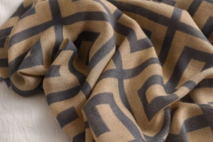 Detailed close-up of geometric pattern scarf with linen texture in earthy tones
