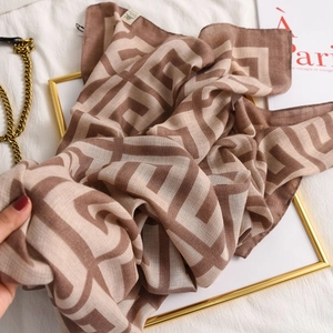 Detail of soft cotton-linen scarf showing fine hemmed edges and brown geometric patterns