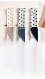 Detailed view of 5x90cm polka dot faux silk skinny scarves in beige, blue and navy