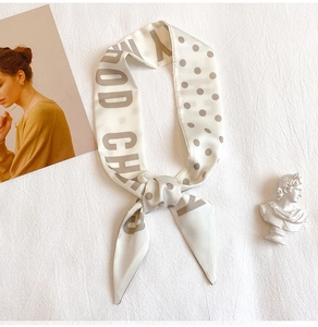 Elegant polka dot letter silk twilly scarf shown with aesthetic French decor props
