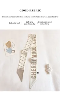 Detailed view of beige polka dot silk scarf with Cherry Mood text and 100% polyester tag