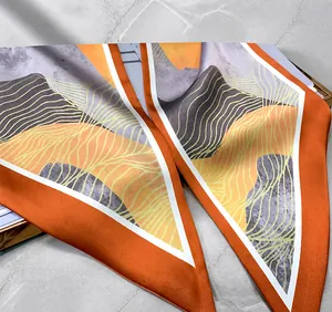 Détail du long foulard en soie montrant la couture intérieure fine et le motif abstrait