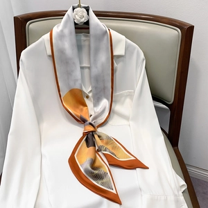 Elegant skinny silk scarf with orange abstract art pattern styled on a white shirt