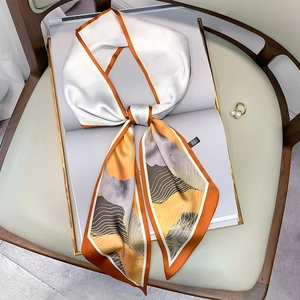 Detailed view of an oil painting style silk scarf tied on a minimalist art book