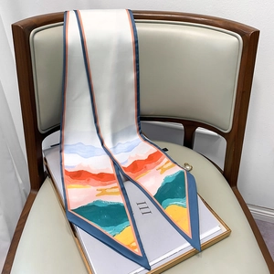 Close-up of a long skinny silk scarf with oil painting landscape print on a wooden chair