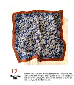 Detail of 12 momme mulberry silk scarf with classic paisley patterns in deep blue and red