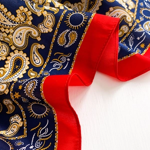 Detail shot of blue and red paisley mulberry silk scarf showing texture and pattern