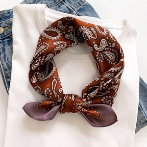 Caramel silk scarf with white paisley print and purple border styled on a denim jacket