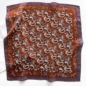 Close-up of rust red paisley silk scarf with lilac trim and intricate pattern detail