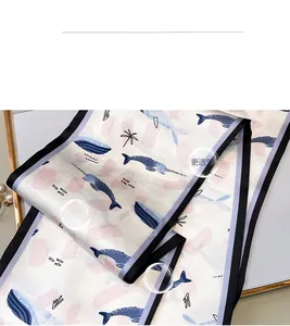 Nahaufnahme des Seidenschals mit Marine-Wal-Prints und Early Spring Story-Aufschrift