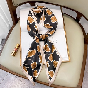 Detailansicht eines floral bedruckten schwarzen Seidentuchs mit elegantem Knoten