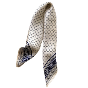 Elegant silk scarf for women featuring navy geometric patterns on a cream background