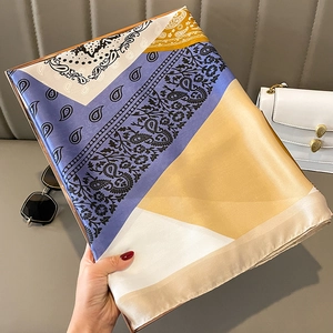 Detail van een zijden sjaal met meerkleurige patchwork en paisley bloemmotieven