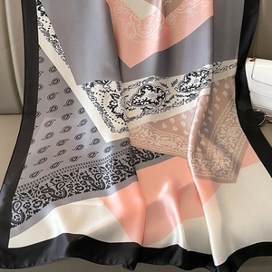 Detailopname van een elegante zijden sjaal met paisley-motief en satijnen glans