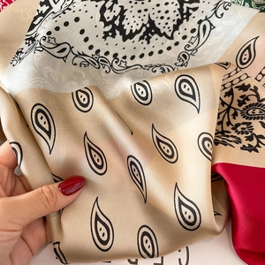 Detail van een satijnen sjaal met paisley-print en zachte zijdeachtige textuur