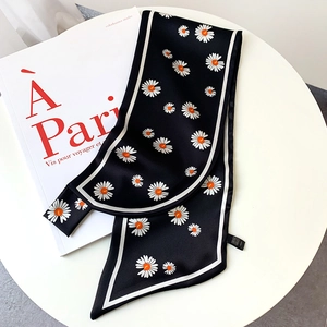 Detail of black daisy print silk scarf with white edging on French book and table