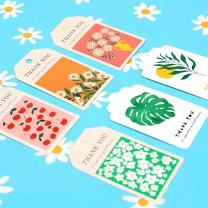 Detailed close-up of floral gift tags with hemp rope and vibrant botanical patterns