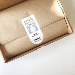 Detail of rectangular thank you stickers with daisy flowers on brown cardboard box