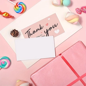 Detailed view of pink heart Thank You cards with white envelopes and festive decor